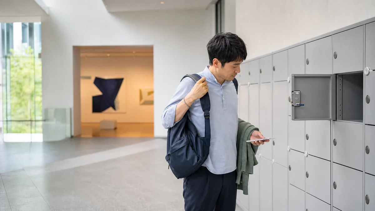 美術館のコインロッカーで展示室へ入る前にリュックを下ろす日本人来館者