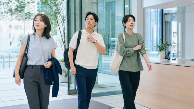 夏の通勤後にオフィス入口で服装を整える会社員3人